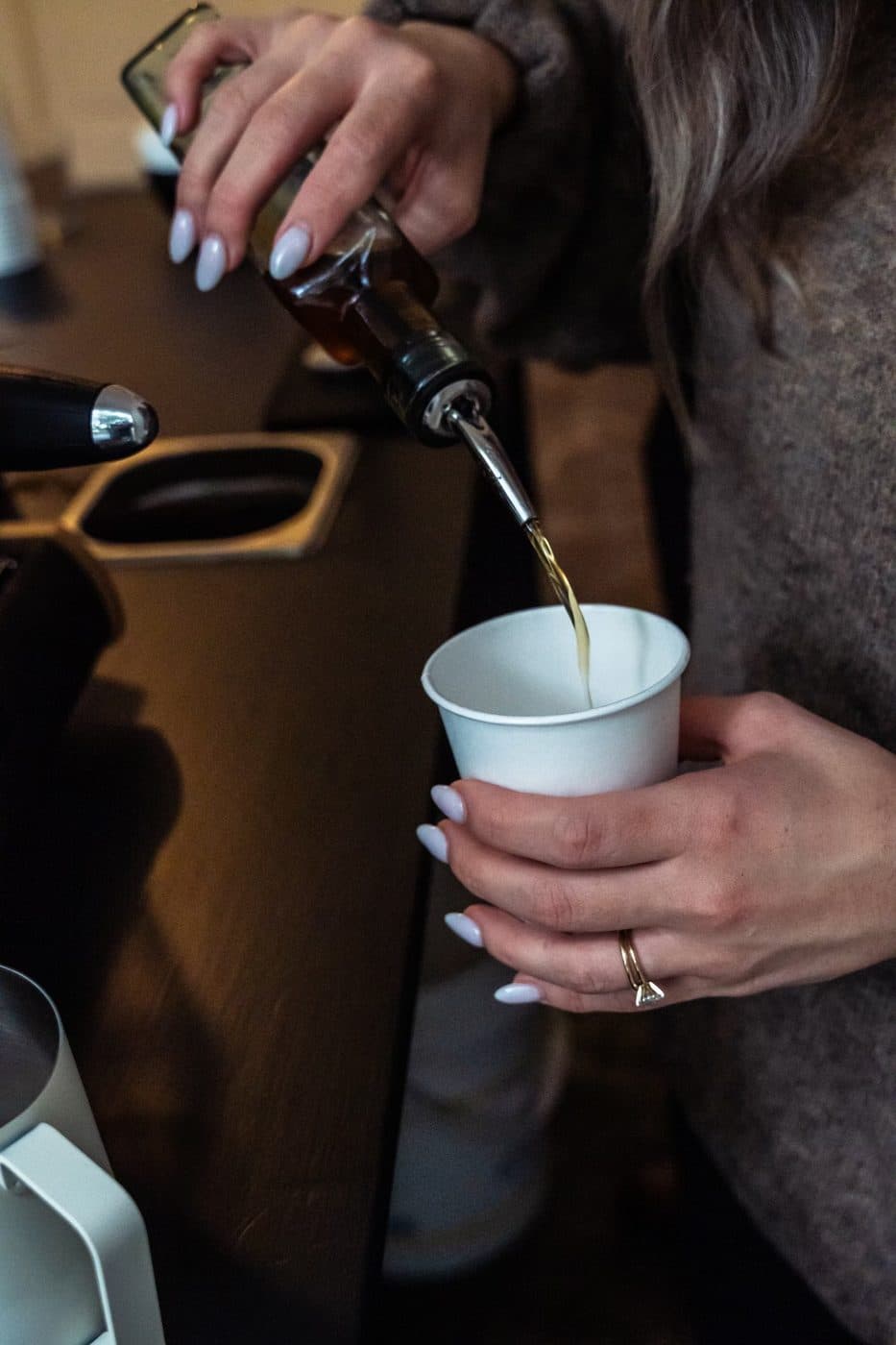 Barista adding housemade syrup to a latte at an event