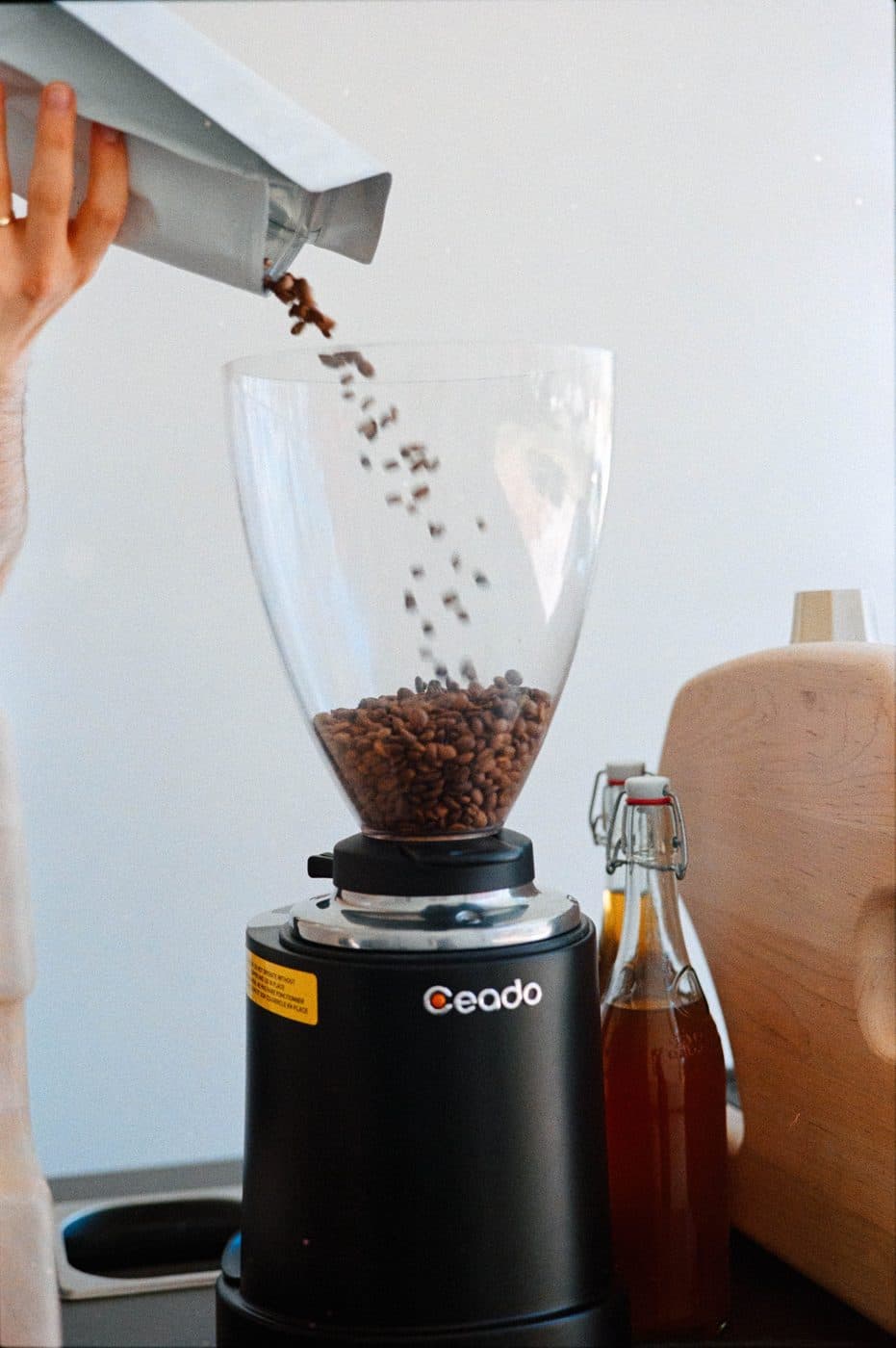 Fresh-roasted organic coffee beans going into the grinder on the coffee cart