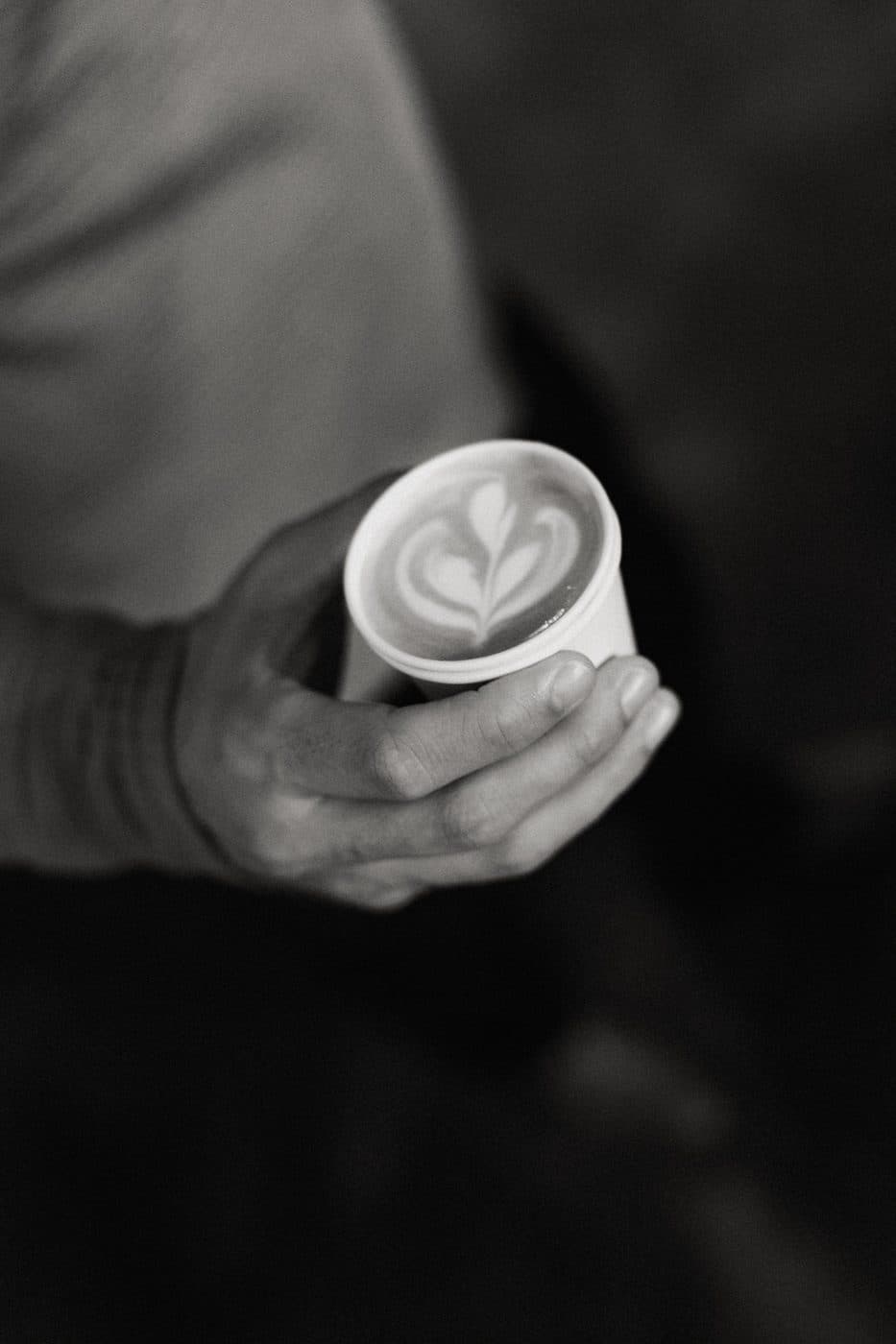 Guest holding a latte with latte art from the Clement Coffee cart