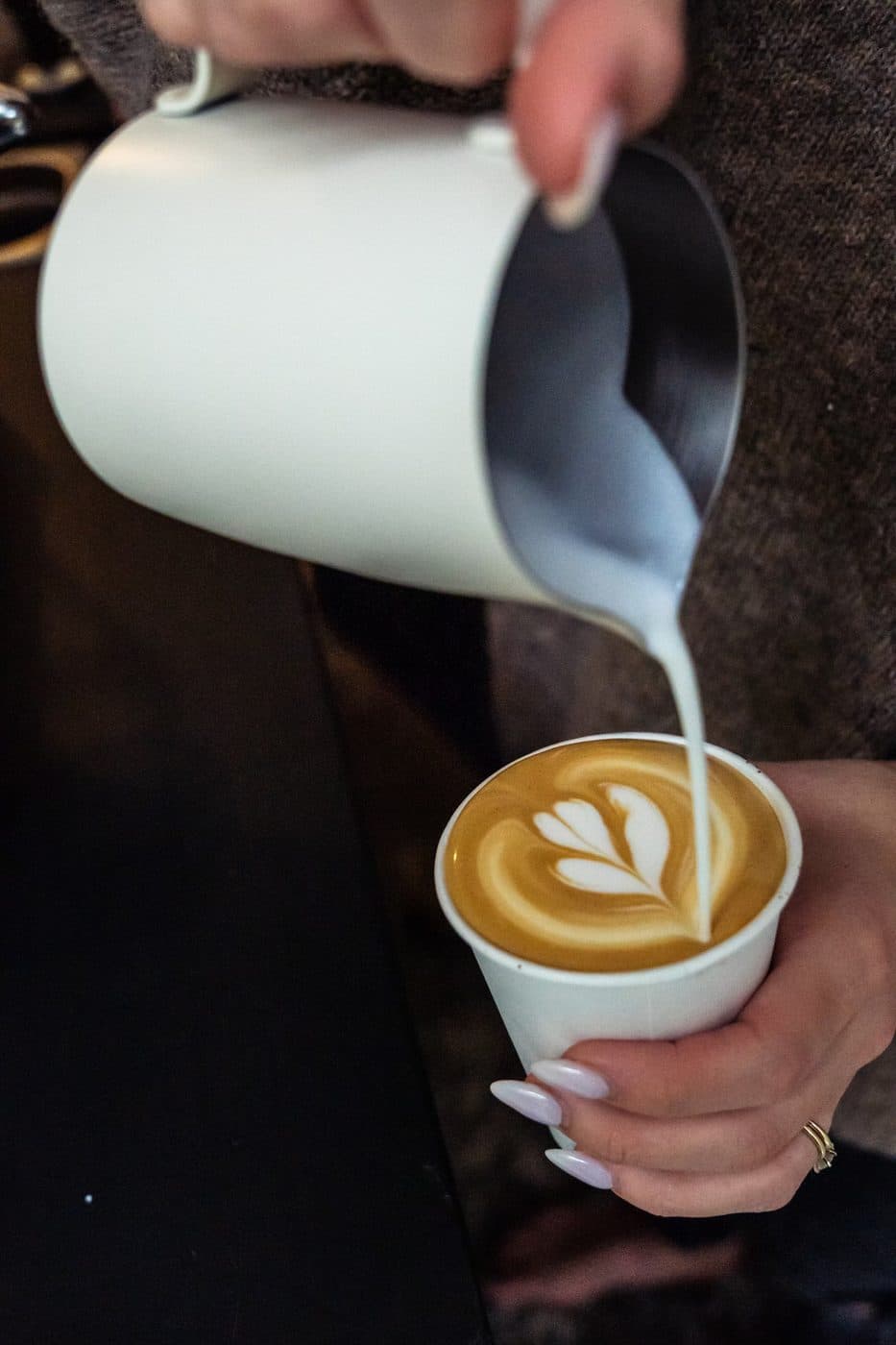 Barista pouring latte art at a catered coffee cart event