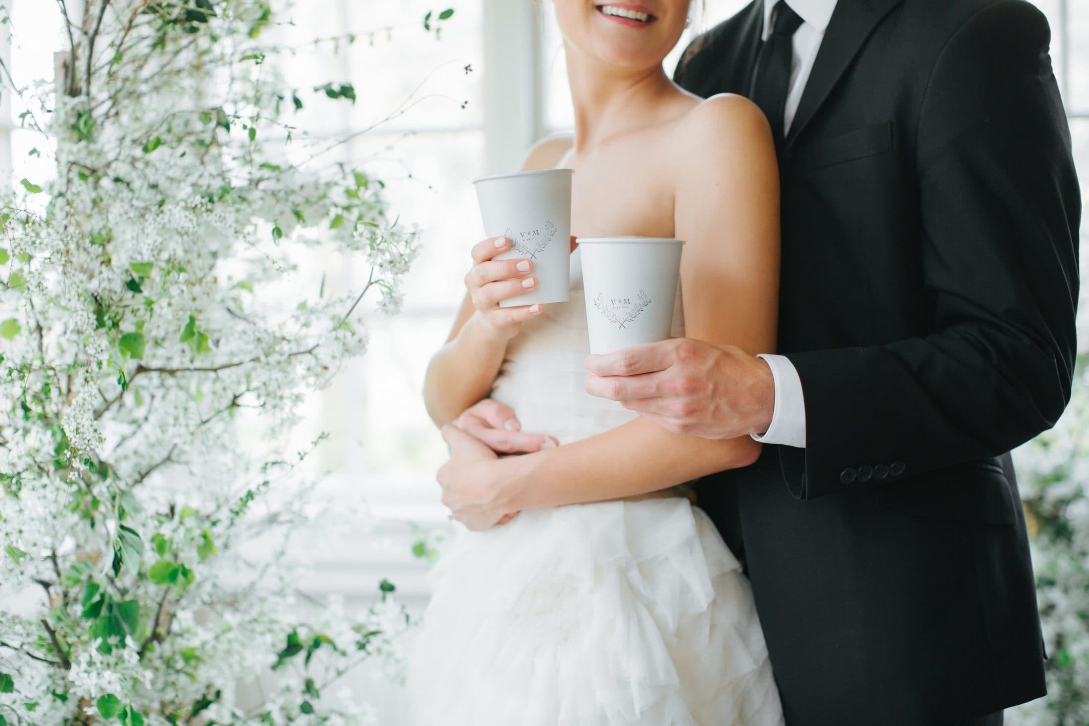 Bride and groom holding custom Clement Coffee cups at their wedding coffee cart